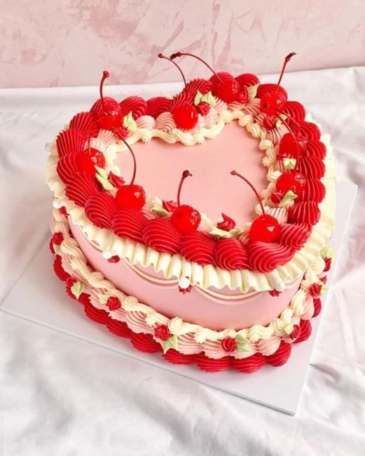 red and pink heart-shaped cake with cherries