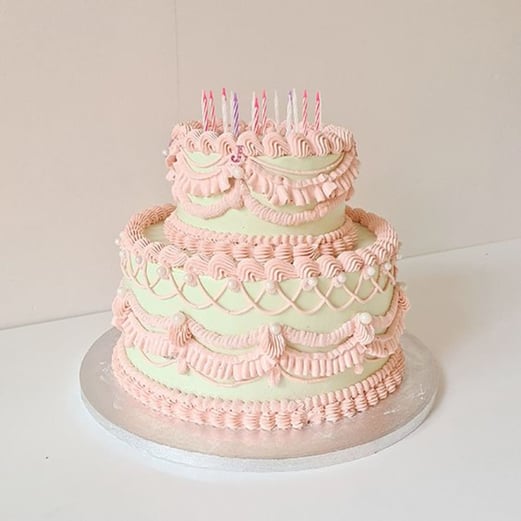 two-tiered pastel-colored kitsch buttercream birthday cake
