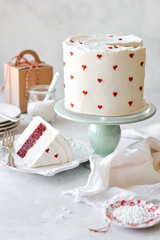 white cake with tiny red hearts decoration